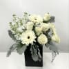 White roses and gerbera daisies in a black vase