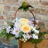 Basket arrangement with pale yellow roses and lavender daisies