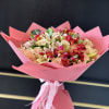 Pink-wrapped bouquet of peach roses and mixed lilies