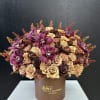 Bouquet of purple orchids and dried roses in a brown box
