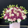 Pink, white, and peach roses in a round pink box with lily buds