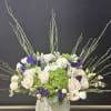 Bouquet of cream and purple roses in a white vase