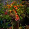 Tall mixed bouquet with orange roses and pink dahlias in a glass vase