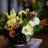Mixed floral arrangement in a black bowl with white star pattern
