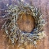 Rustic twig wreath with pale lichen on a wooden background
