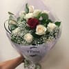 11 white roses with one single red rose in the middle, wrapped