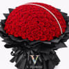 Large dome bouquet of red roses with a pearl strand and black wrapping paper.