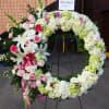Heart-shaped floral wreath with pink and white flowers on an easel