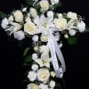 White floral standing spray with roses, lilies, and carnations on a black background