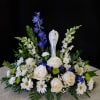White and blue floral arrangement with a central angel figurine