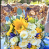 Bouquet of yellow sunflowers and white roses with purple accents