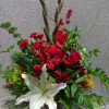 Red roses and white lilies in a glass vase with tall decorative branches
