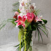 Includes Cymbidium orchids, Protea, Stargazer lilies, Safari sunset, Amaranthus in a Tall