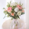 Blush and cream: pink ranunculus, a white peony, garden roses and lisianthus