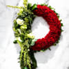 Heart-shaped floral wreath with red roses and green-white flowers