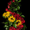 Tall arrangement of red roses and yellow sunflowers in a vase