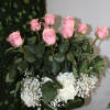 Pink roses and white flowers arranged in a clear glass vase