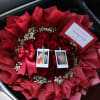 Bouquet of red roses with baby’s breath, ribbon, and photo clips in a car seat