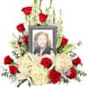 Memorial floral frame with red roses, white lilies, and a portrait