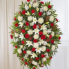 Standing floral spray with red roses, white lilies, and white chrysanthemums