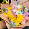 Bouquet of pink roses, yellow chrysanthemums, and white daisies in pink wrap