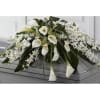 White calla lilies and orchids arranged on a casket
