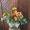 Mixed bouquet in a glass vase with lilies, roses, and yellow daisies