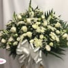 White floral spray with roses and daisies, finished with a silver bow