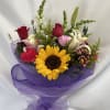 Mixed bouquet with a sunflower, roses, lilies, and purple wrapping