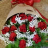 Bouquet of red roses with white baby's breath in kraft paper and a red ribbon