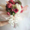 Hand-tied bouquet of pink and white flowers with trailing white orchids