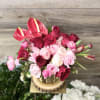 Pink and red roses with red anthuriums arranged in a wooden container