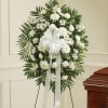 White funeral wreath with daisies and carnations on a stand