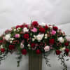 Large arrangement of red, white, and pink roses in a tall vase