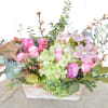 Pink roses and green hydrangeas in a white wooden box with eucalyptus