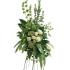 Tall standing floral spray with white roses and green foliage on a metal easel