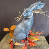 Blue glitter rabbit figurine with autumn leaves on a stone base