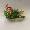 Tropical plant arrangement with red anthuriums in a gold boat planter