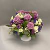 Lavender roses and purple flowers arranged in a white vase