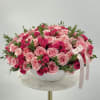 Round bouquet of pink and hot pink roses in a white bowl vase