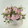 Pink and lavender rose bouquet in a white vase