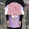 Pink roses arranged in a lavender gift box with white bunny ears and bows