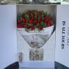 Boxed bouquet of red tulips with green leaves