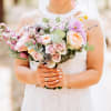 Bride holding a pastel bouquet of roses and mixed flowers
