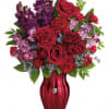 Red roses and purple flowers arranged in a red vase