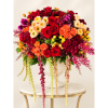 Large mixed rose arrangement in a white urn with cascading blooms