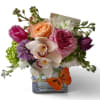 Mixed bouquet in a square glass vase with roses, orchids, and tulips