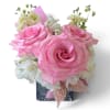Pink roses and white flowers arranged in a square glass vase