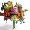 Handheld bouquet of mixed colorful flowers with a green ribbon wrap