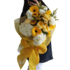 Handheld bouquet of yellow and white flowers wrapped in gold mesh